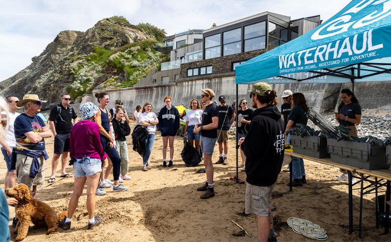 Group of people having a safety briefing before a beach clean.