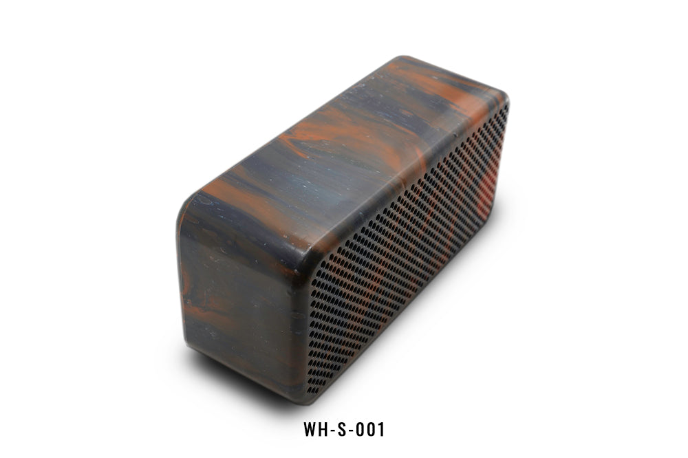 Black and orange rectangular speaker with marbled surface on a white background