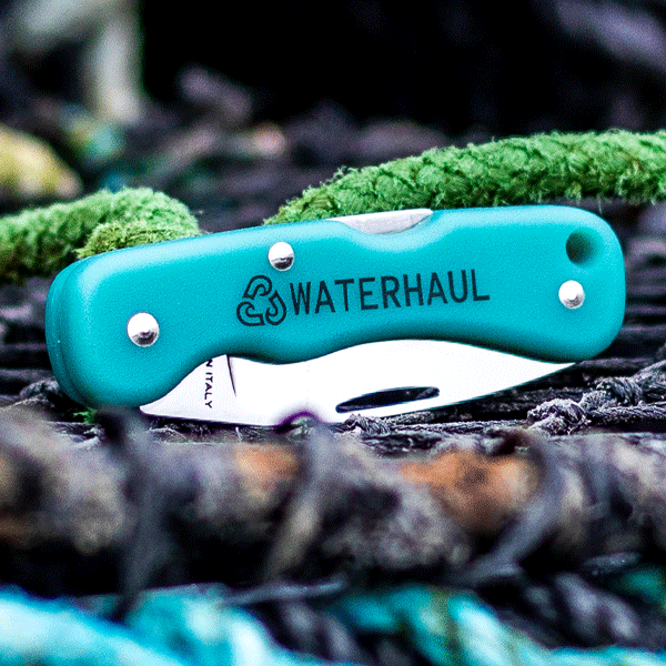 Turquoise pocket knife with 'WATERHAUL' branding on a natural background
