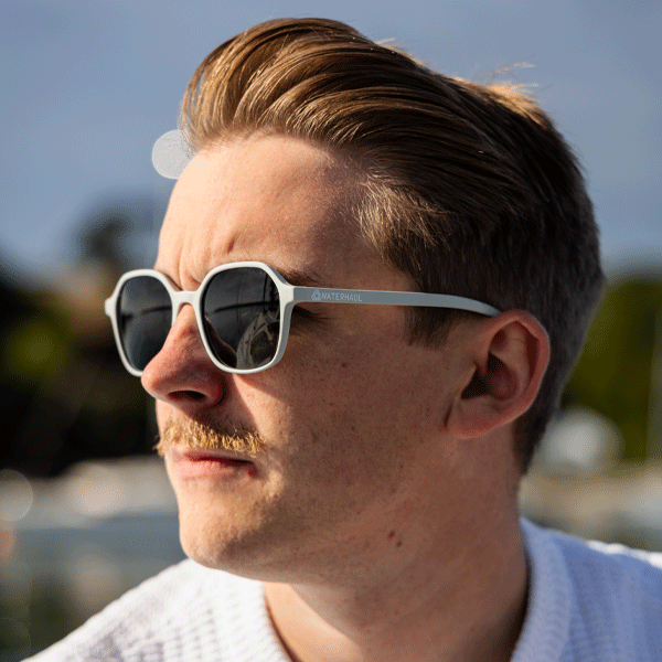 Man wearing sunglasses with a blurred outdoor background