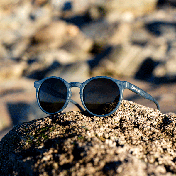Round blue sunglasses on a rocky background