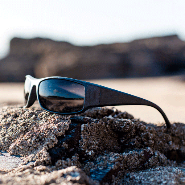 Sunglasses on a rock with a blurred natural background