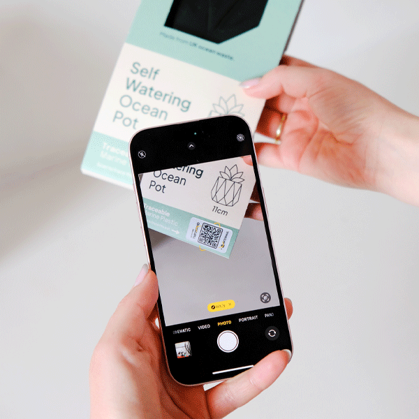 Person using a smartphone to scan a traceability QR code on a product packaging